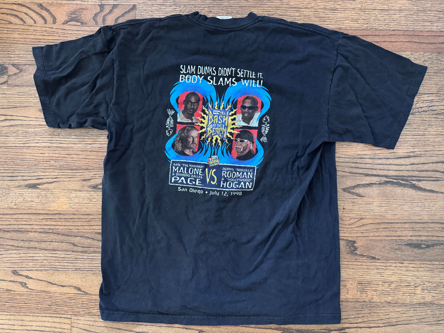 1998 WCW / n.W.o. Bash at the Beach event shirt featuring “Hollywood” Hulk Hogan, “Rodzilla” Dennis Rodman, “The Mailman” Karl Malone and Diamond Dallas Page

Size: XXL
