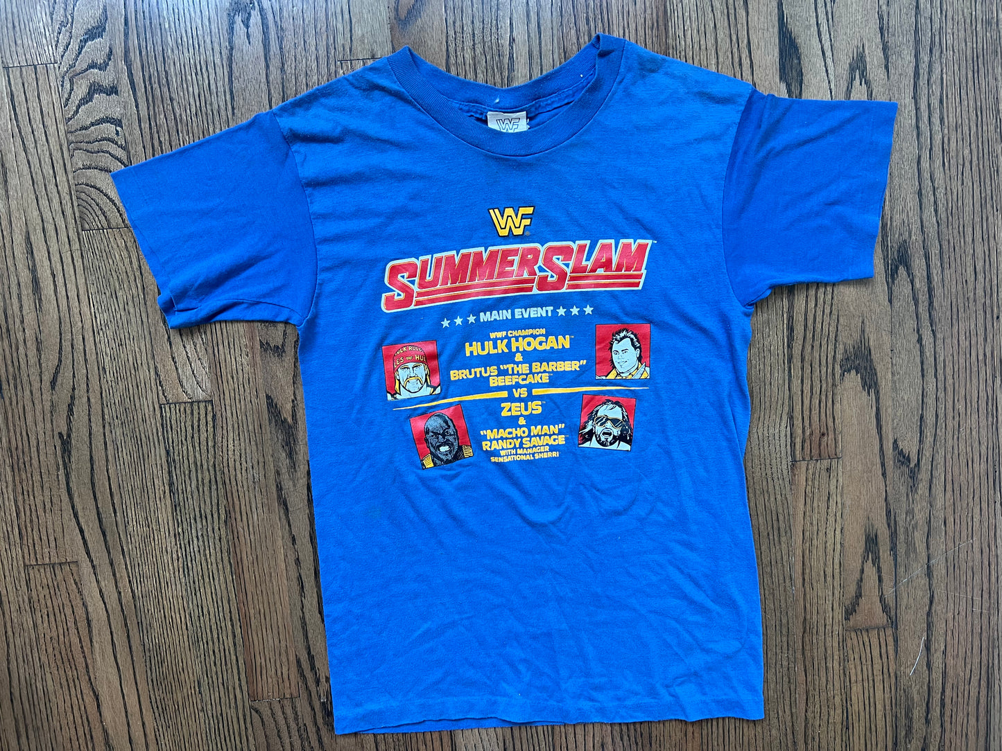 1989 WWF Summerslam two sided shirt featuring “The Human Wrecking Machine” Zeus, “Macho Man” Randy Savage, Hulk Hogan and Brutus “The Barber” Beefcake